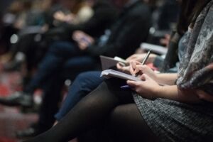 People taking notes while seated