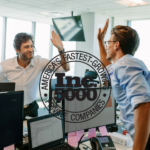 Two men giving each other high-fives in an office