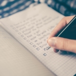 Man building a prospecting tools list in a notebook