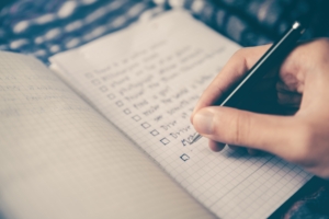 Man building a prospecting tools list in a notebook